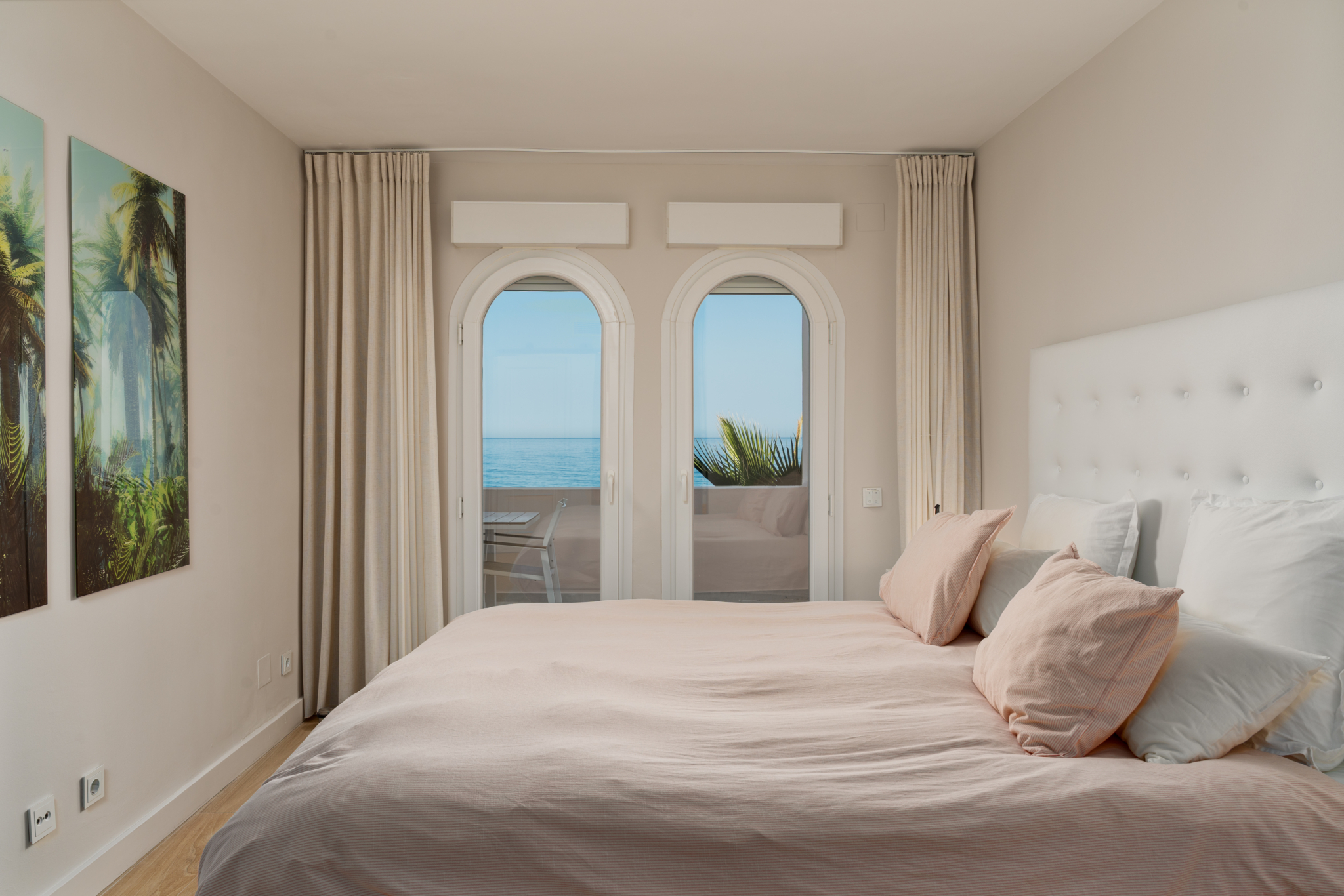 Bright bedroom with soft pink bedding and modern en-suite design in Playa del Moral apartment