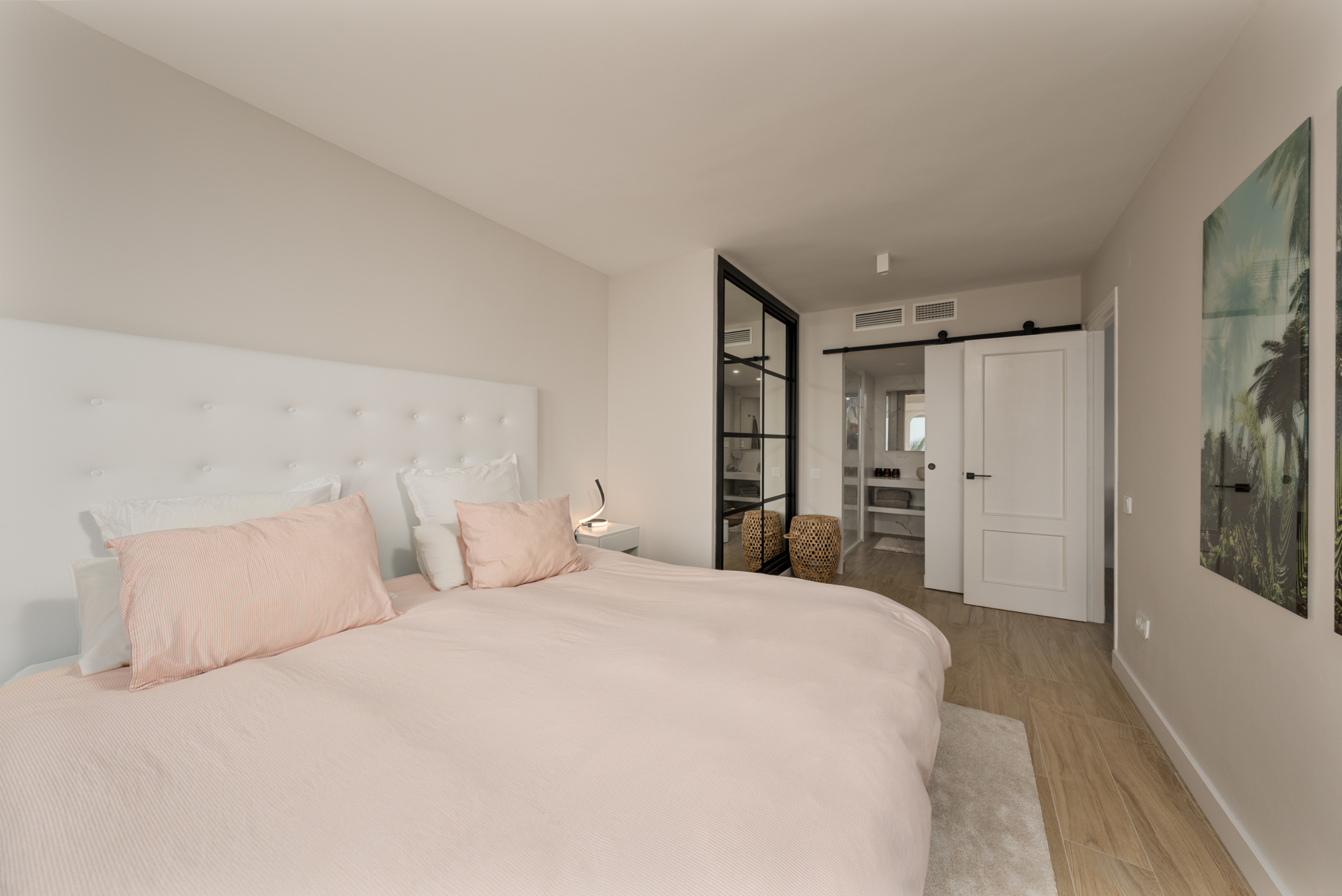 Bright bedroom with soft pink bedding and modern en-suite design in Playa del Moral apartment
