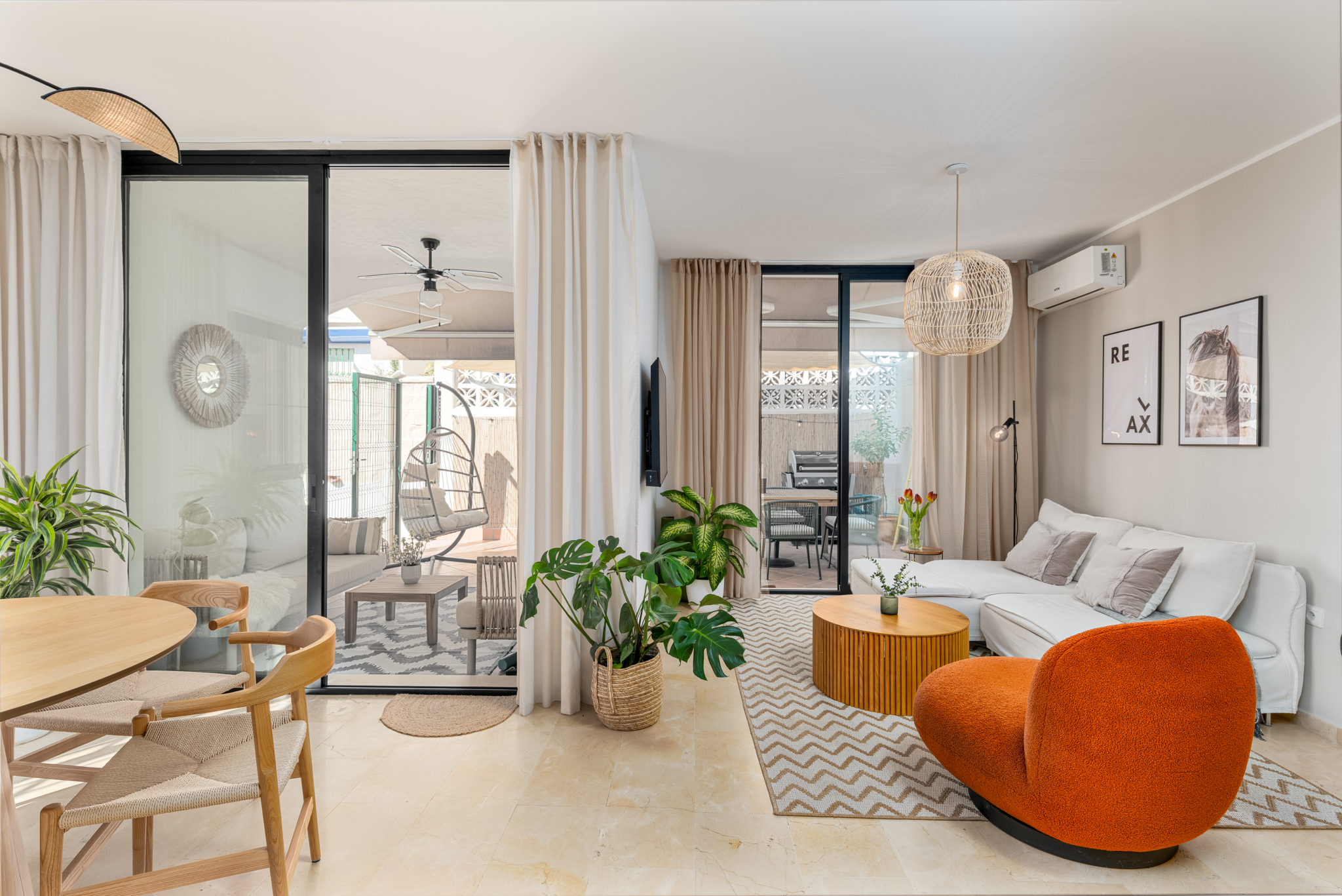 Modern living room in Bel-Air semi-detached home near Marbella, featuring neutral tones, indoor plants, and open access to a stylish terrace