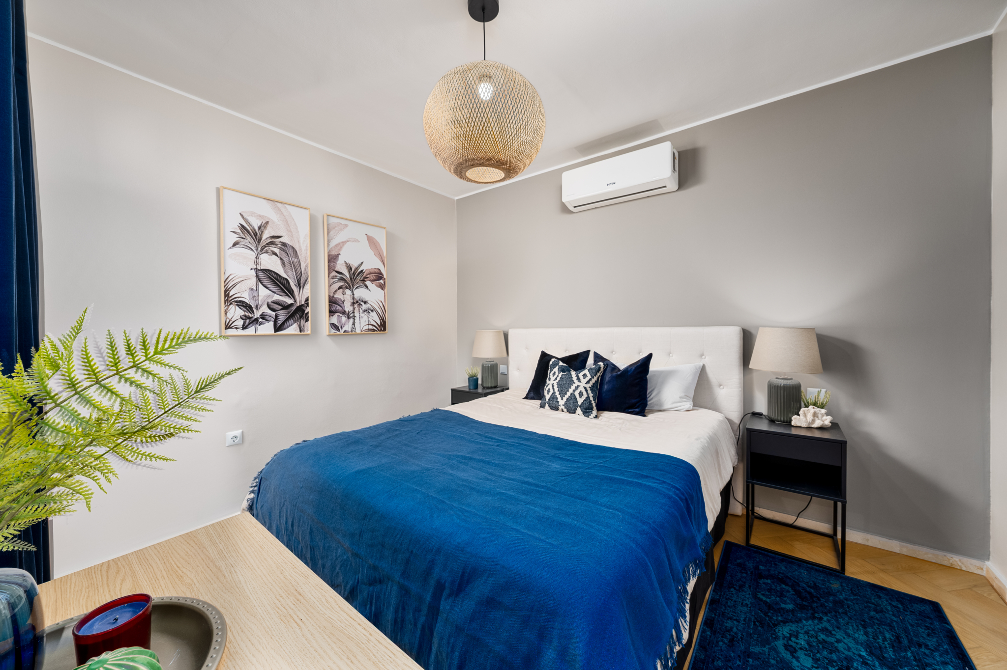 Stylish bedroom in Bel-Air semi-detached home near Marbella, featuring modern decor with neutral walls, blue accents, wall art, and contemporary lighting