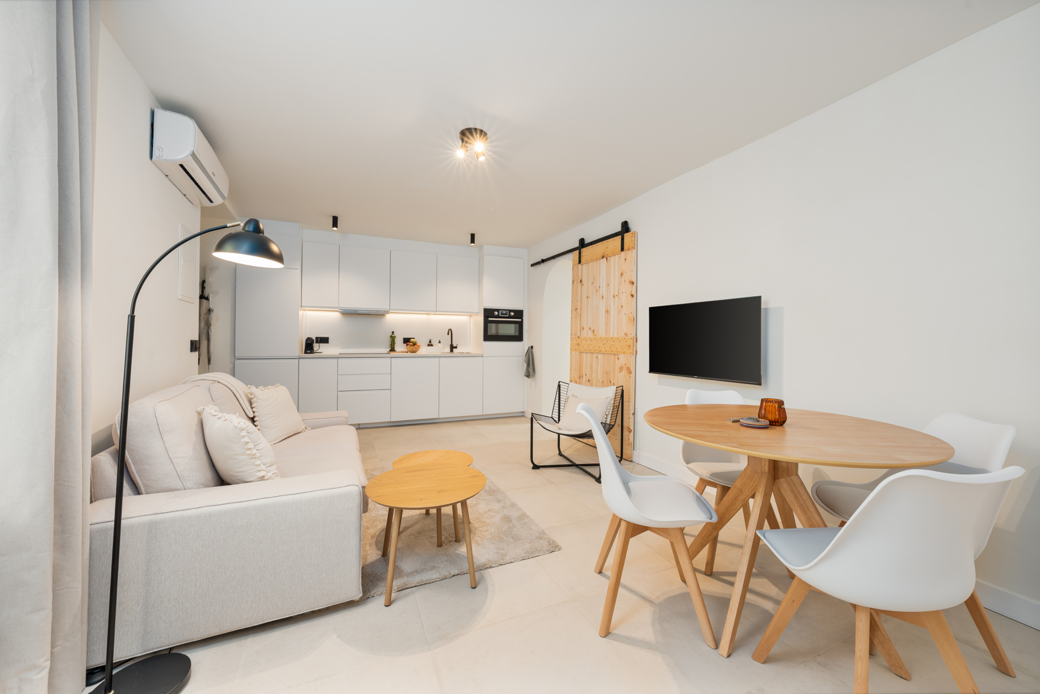 Bright open-plan living room and modern kitchen with Scandinavian decor in Estepona old town apartment
