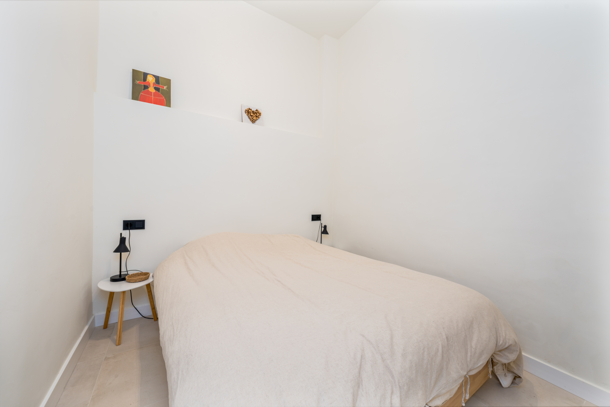 Cozy minimalist bedroom with neutral tones and simple decor in Estepona old town apartment.