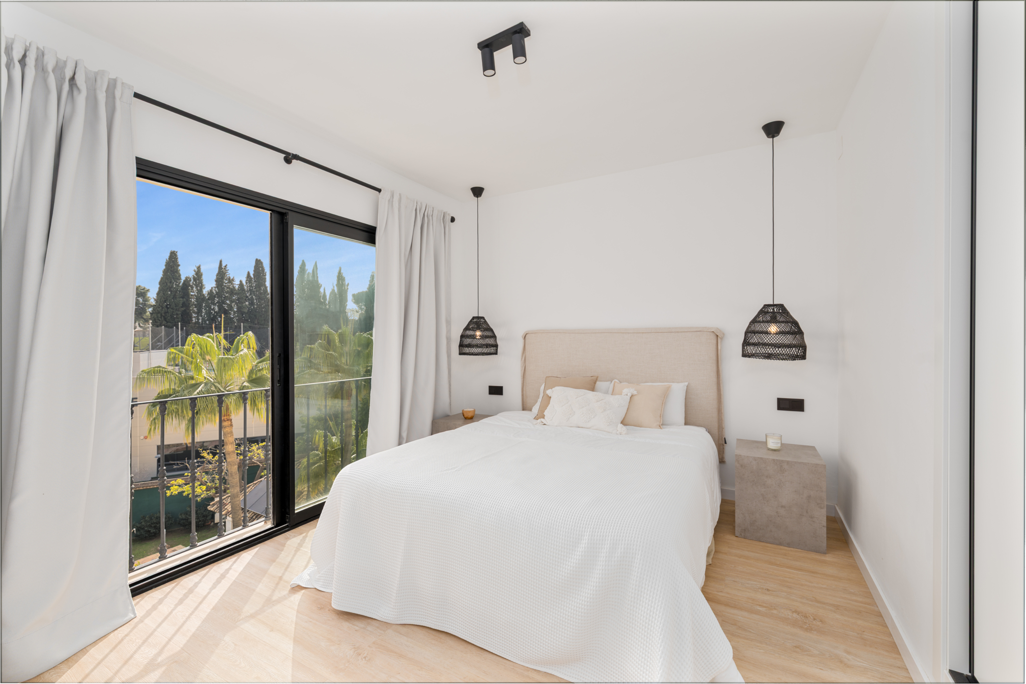 Bright bedroom with large windows and modern decor at Los Pinos de Aloha, Marbella.