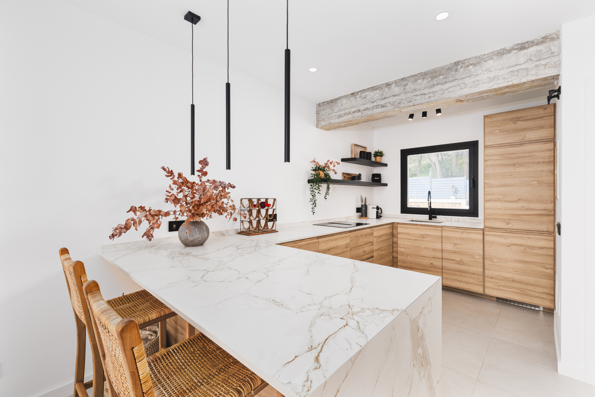 Modern kitchen interior with marble island, wooden cabinets, and minimalist lighting in Los Pinos, Marbella