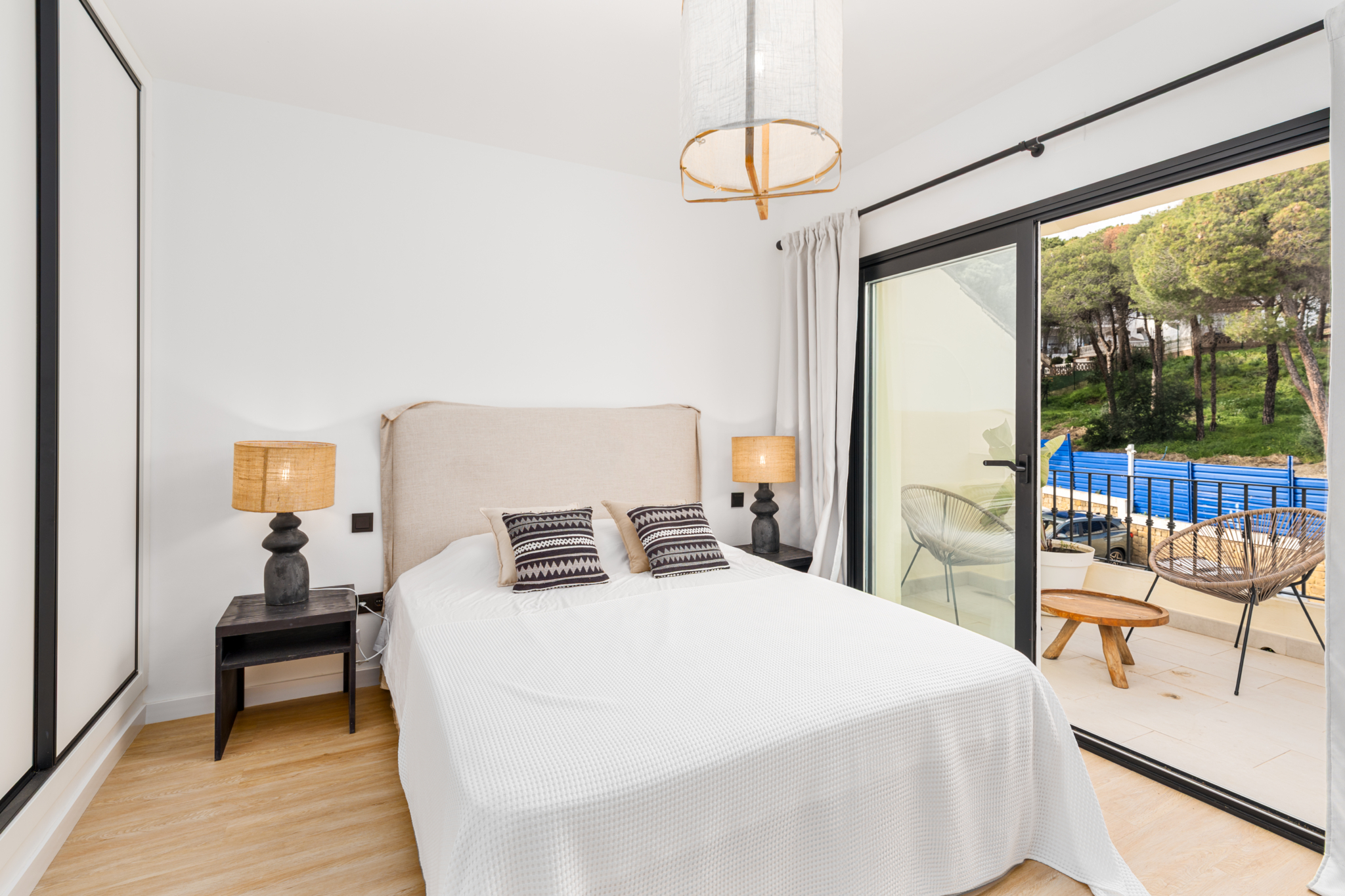 Bright bedroom with large windows and modern decor at Los Pinos de Aloha, Marbella.