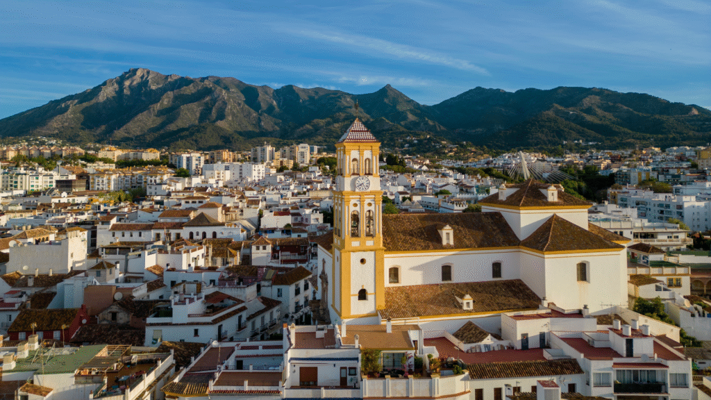 Aerial view of Marbella old town with church tower and mountain backdrop, representing property and mortgage opportunities in southern Spain.