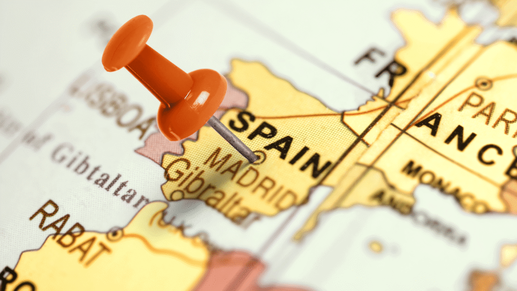 Close-up map of Spain with a red push pin marking Madrid, symbolizing real estate purchase and investment locations in Spain and illustrating key steps for bying property in Spain.