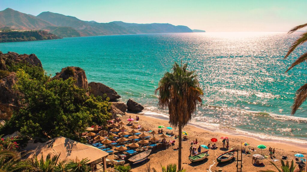 Beautiful beach on the Costa del Sol in Spain with turquoise sea and sun umbrellas, ideal for property investment.