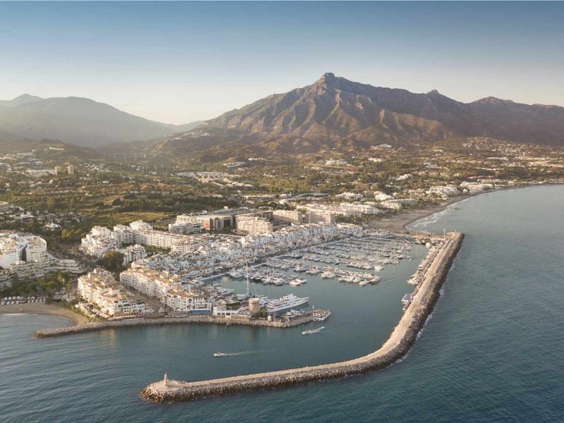 Aerial view of Puerto Banús marina and the exclusive neighborhoods in Nueva Andalucia, Marbella, with La Concha mountain in the background.